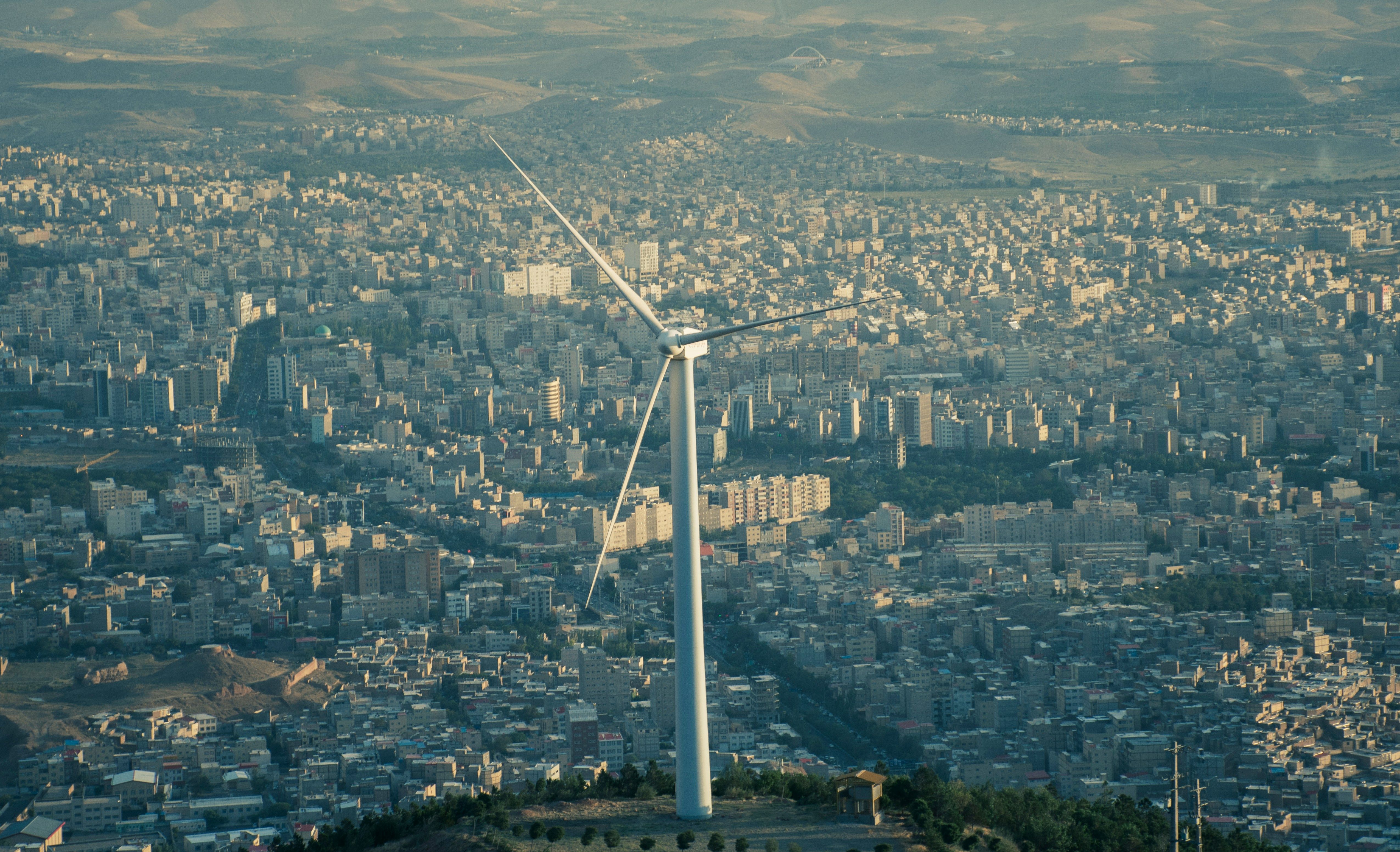 Windkraftwerk mit Stadt im Hintergrund